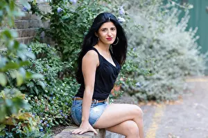 Indian Ethnicity Prints: Beautiful Indian woman sitting on a wall