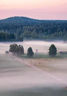 Beautiful landscape view with fog and meadow at summer evening in countryside, Finland