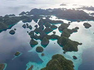 Beautiful limestone islands are fringed by coral reefs in Wayag, Raja Ampat, Indonesia. This region is known for its amazing marine biodiversity