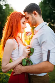 Beautiful love couple hugs in summer park on sunset