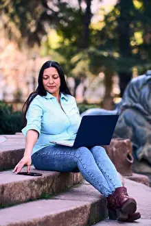 Concentrate Prints: Beautiful mature Latina woman working on her laptop outdoors at home