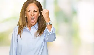 Punching Prints: Beautiful middle age business adult woman over isolated background angry and mad raising fist frustrated