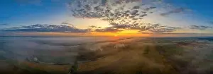 Awakening Prints: Beautiful morning with upraising fog over a panoramic field view at sunrise pure nature