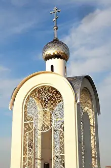 Gold Colored Prints: A beautiful Orthodox chapel with a golden dome and a cross against a blue cloudy sky