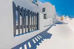 Beautiful panoramic street view on the mediterranean blue sea, caldera and volcano. Traditional white architecture of Santorini island, Thira, Greece