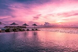Images Dated 30th May 2019: Beautiful poolside and sunset sky with palm trees. Luxury tropical beach landscape