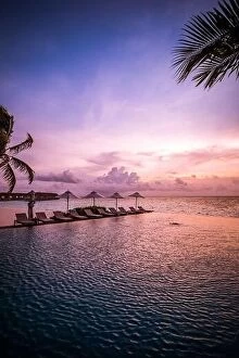 Images Dated 30th May 2019: Beautiful poolside and sunset sky with palm trees. Luxury tropical beach landscape