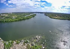 The beautiful river is surrounded by green and fresh vegetation in the city