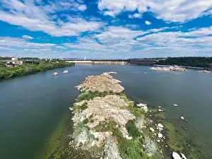The beautiful river is surrounded by green and fresh vegetation in the city