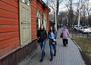 Beauties Prints: Beautiful Russian women walking by an old traditional wooden house in Irkutsk