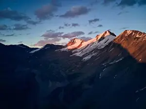 Beautiful scenery of the mountains with snow glacier silhouette at blue sunset sky Almaty