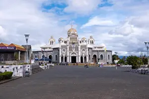 Praying Prints: A beautiful shot of the Basilica of Our Lady of the Angels against blue cloudy sky on a sunny day in Cartago
