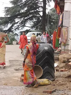 Sari Prints: Beautiful, slender Indian woman in a sari pauses while at work carrying rubble on her head