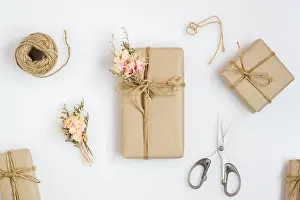 Handcrafted Prints: Beautiful small handmade DIY gift box (package) with flowers and decorative rope on white background