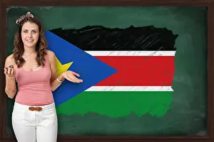 Tutor Prints: Beautiful and smiling woman showing flag of XXXXXXX on blackboard
