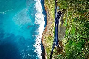 High Above Prints: Beautiful and stunning bird's eye view of a yellow car driving between two tunnels on a cliff road in Madeira