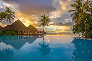 Beautiful sunset beach scene. Colorful sky and clouds view with calm sea and relaxing tropical mood, over water villa. Exotic travel landscape