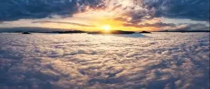 Smoky Prints: Beautiful sunset sky above the clouds with silhouettes of mountain peaks with dramatic light