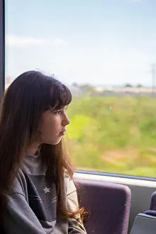 Hopeful Prints: Beautiful teenage girl with long brown hair rides a commuter train and looks out the window
