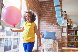 Childcare Prints: Beautiful toddler wearing glasses and unicorn diadem standing and smiling at kindergarten