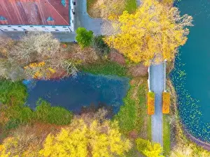 Foot Bridge Prints: Beautiful travel or tourism style look down aerial of pedestrian foot bridge across River at park with colorful fall