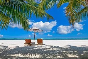 Images Dated 17th December 2018: Beautiful tropical island scenery, two sun beds, loungers, umbrella under palm tree