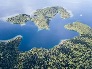 Beautiful, tropical islands rise from the seascape in Raja Ampat, Indonesia. This remote region is known as the heart of the Coral Triangle