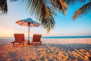 Images Dated 5th January 2017: Beautiful tropical sunset scenery, two sun beds, loungers, umbrella under palm tree