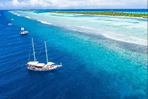 Beautiful turquoise ocean water boat top view aerial photo. Aerial view speed boat in the sea. Exotic sea lagoon, snorkel adventure, tropical ocean