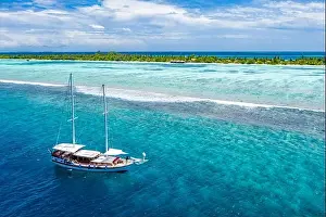 Beautiful turquoise ocean water boat top view aerial photo. Aerial view speed boat in the sea. Exotic sea lagoon, snorkel adventure, tropical ocean