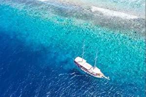 Beautiful turquoise ocean water boat top view aerial photo. Aerial view speed boat in the sea. Exotic sea lagoon, snorkel adventure, tropical ocean