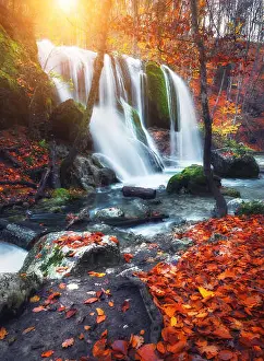 Motion Blur Prints: Beautiful waterfall at mountain river in colorful autumn forest with red and orange leaves at sunset