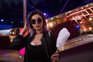 Softness Prints: Beautiful woman holding cotton candy in amusement park at night
