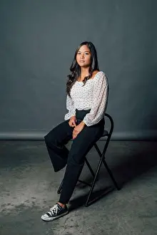 Beautiful Woman Prints: Beautiful serious woman sitting on chair in front of gray backdrop