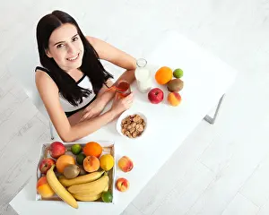 Selective Prints: Beautiful women exists with pure skin on her face sitting at a table and eat breakfast