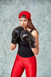 Concentrating Prints: Beautiful young girl boxing gloves near the wall