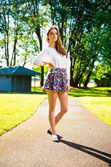 Modeling Prints: A beautiful young girl poses for a fashion style portrait outdoors at a park with natural lighting