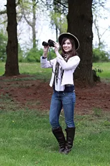 beautiful young lady in the country looking at and studying birds and wild life