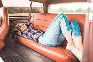 Offroad Prints: beautiful young woman lying on back seat of vintage car in field