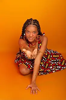 Braids Prints: Beautiful young woman sitting with braids in her hair wearing traditional clothing