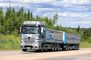 Delivering Prints: Beautifully customized Mercedes-Benz Actros general cargo transporter of Tilaus-Rahti Oy on highway on a day of summer