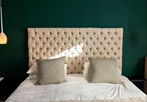 Duvet Prints: Bed is sitting under hanging lamp with tufted headboard
