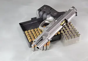 Munition Prints: Beretta 92FS or M9 hand gun open slide and pack of bullets 9mm parabellum isolated on reflection surface