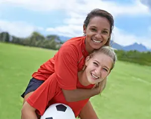 Team Sports Prints: Best friends and teammates. Shot of a female soccer player carrying her teammate on her back