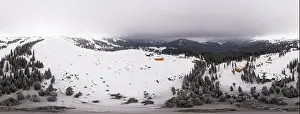 Bewitching beautiful panorama of mountains and hills covered with fir trees on a winter cloudy day