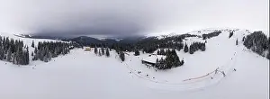 Hill Glacier Prints: Bewitching beautiful panorama of mountains and hills covered with fir trees on a winter cloudy day