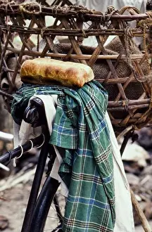 1986 Prints: A bicycle with basket on the back and two loaves of bread on the seat in a small village on Zanzibar Island Africa