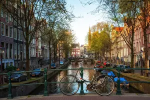 Bicycle on the bridge with Netherlands traditional houses and Amsterdam canal in Amsterdam, Netherlands