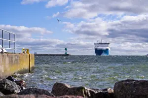 Cruise Ship Prints: a big ferryboat swims past the lighthouse of Tavemuende