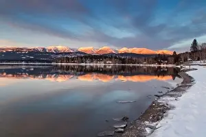 Big Mountain reflected in Whitefish Lake at sunset in winter in Whitefish, Montana, USA
